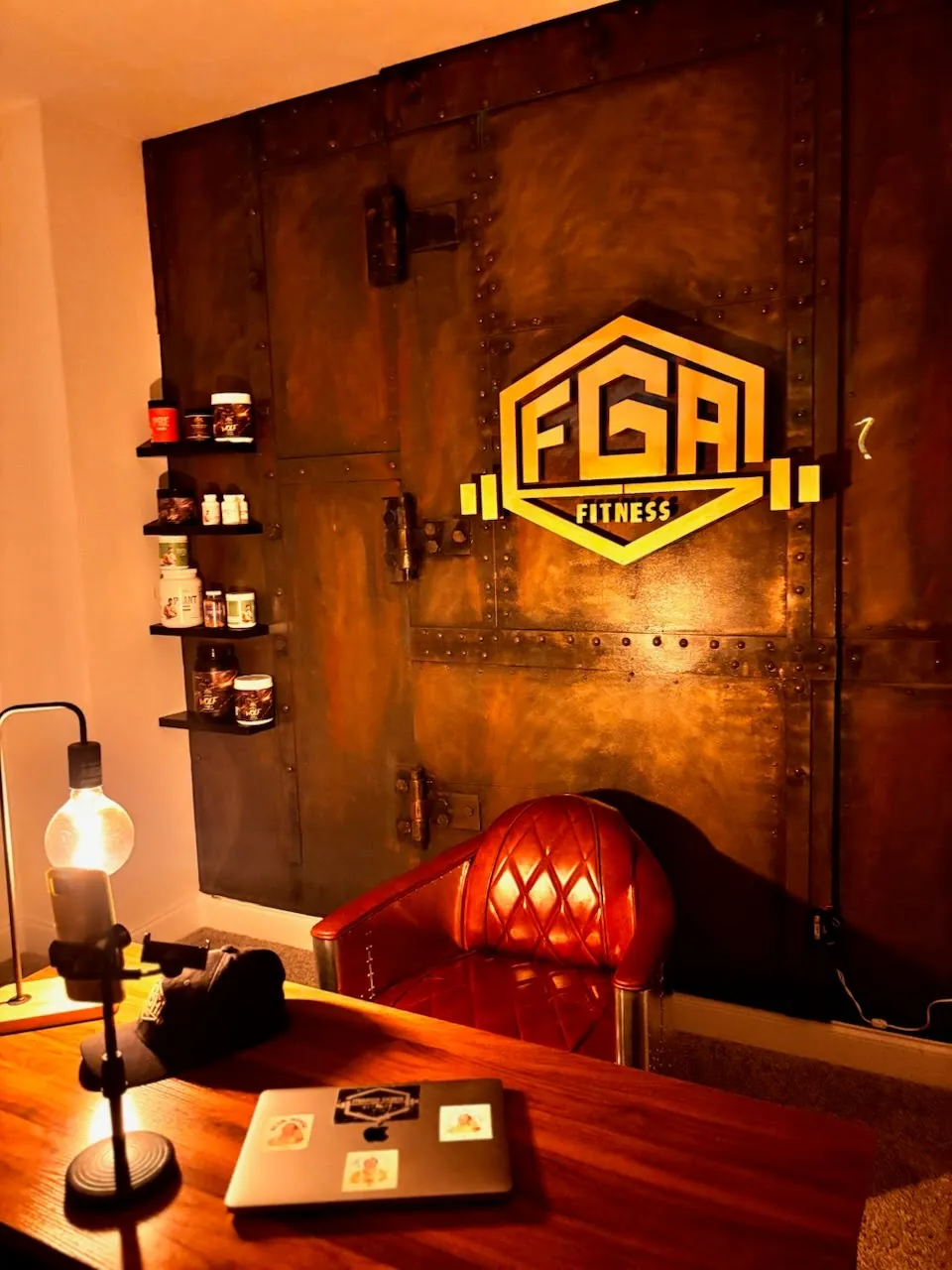 Industrial rust-finish feature wall with a backlit FGA Fitness logo in an office