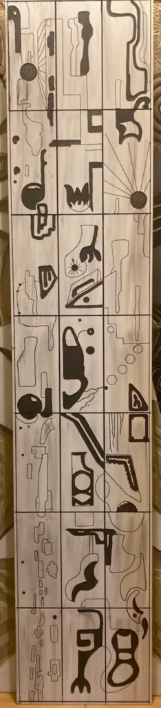 Tall hand-carved wood panel with dark inlaid abstract symbols